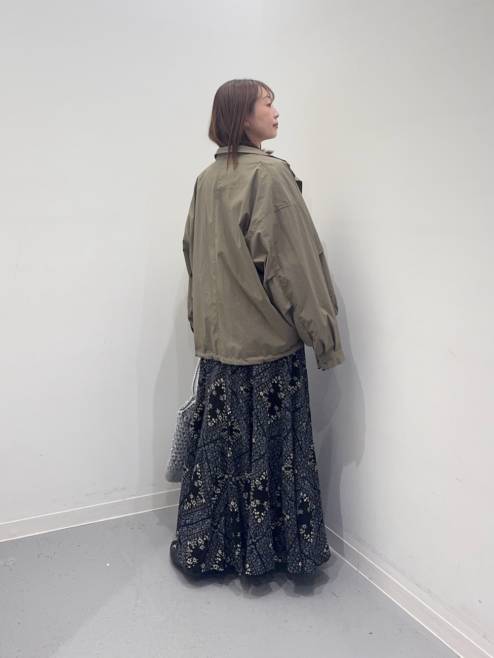 ベージュ系のカーディガン/ボレロ、グリーン系のブルゾン、ブラック系のスカートを着用したレディースの春コーディネートの3枚目の写真