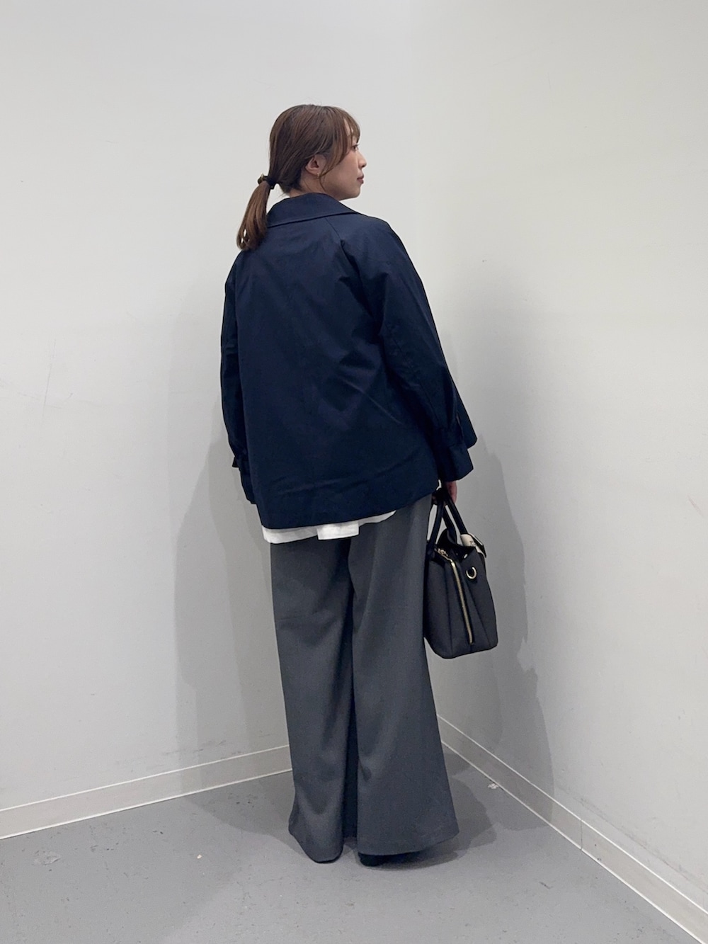 ブルー系のトレンチコート、ホワイト系のシャツ/ブラウス、グレー系のその他パンツを着用したレディースの春コーディネートの3枚目の写真