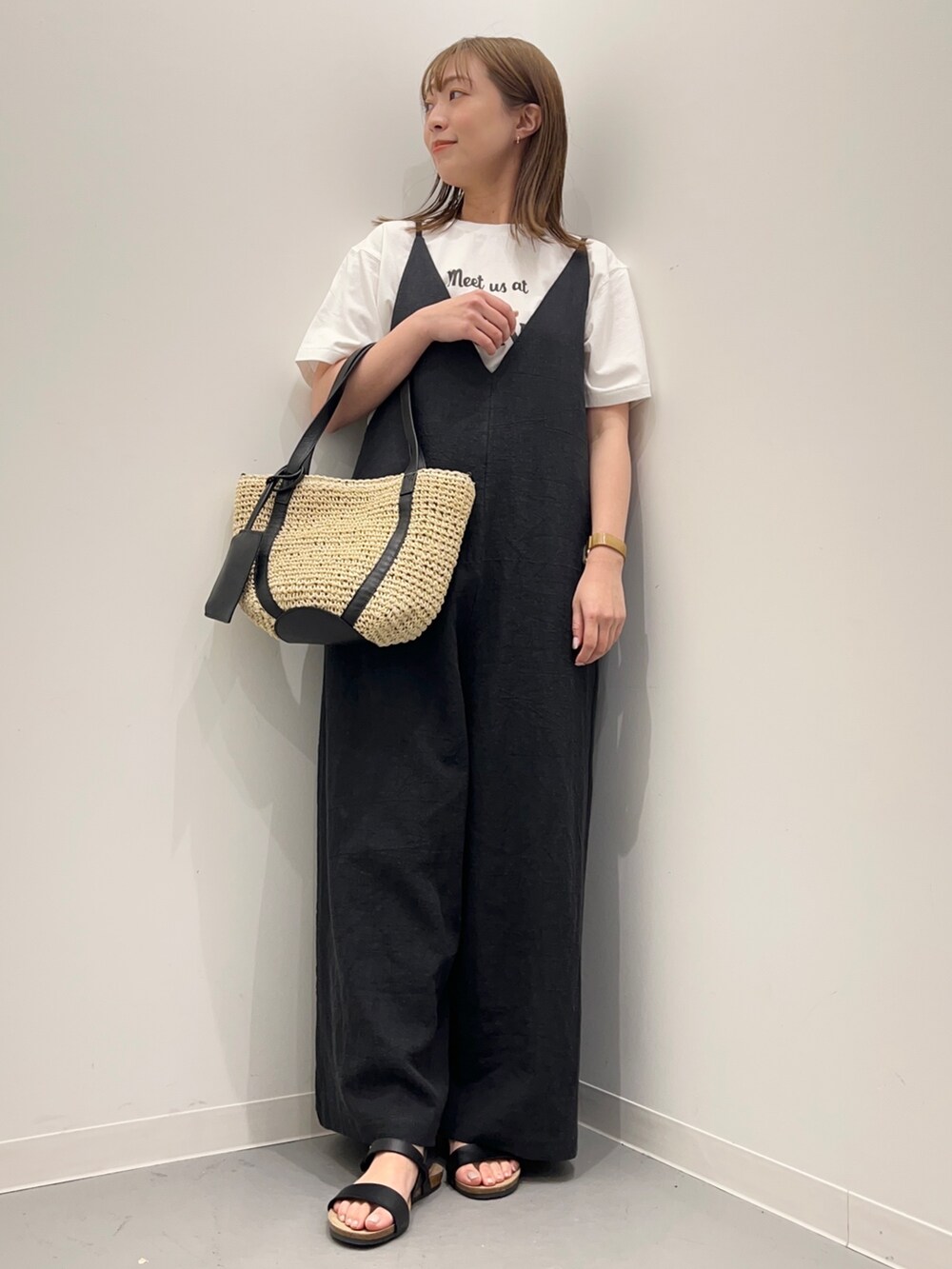 ホワイト系のTシャツ/カットソー、ブラック系のサロペット/オーバーオール、ブラック系のサンダルを着用したレディースの春コーディネートの2枚目の写真