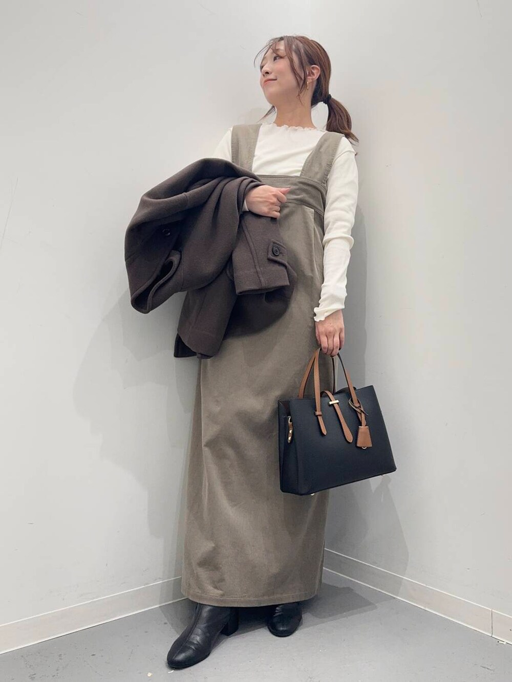 ブラック系のブーツ、ブラック系のトートバッグ、ブラウン系のその他アウターを着用したレディースの冬コーディネートの8枚目の写真