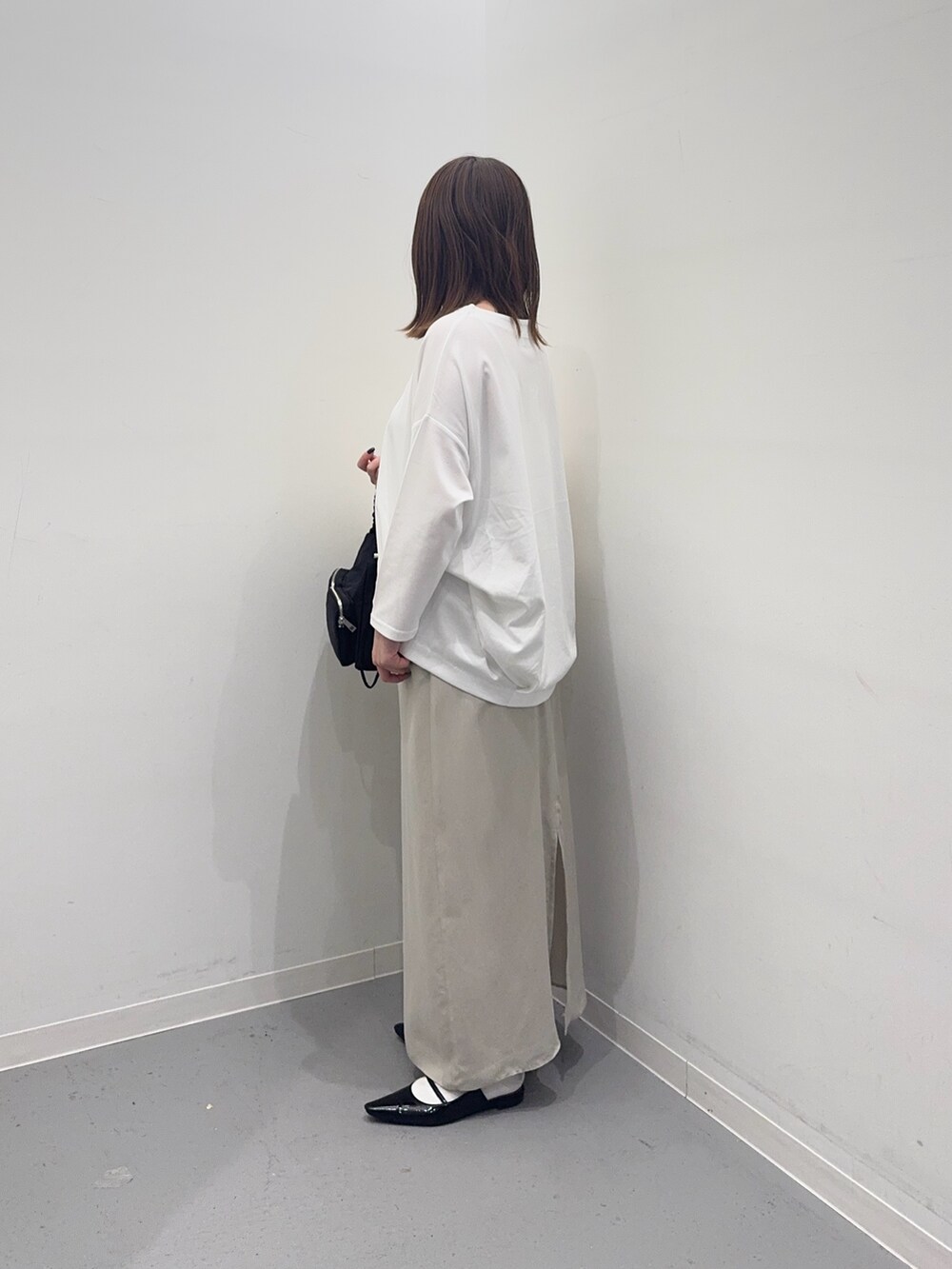 ホワイト系のナイロンジャケット、ベージュ系のスカート、ホワイト系のTシャツ/カットソーを着用したレディースの春コーディネートの6枚目の写真