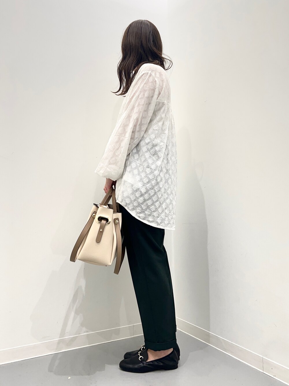 ホワイト系のトップス、グリーン系のパンツを着用したレディースの夏コーディネートの3枚目の写真