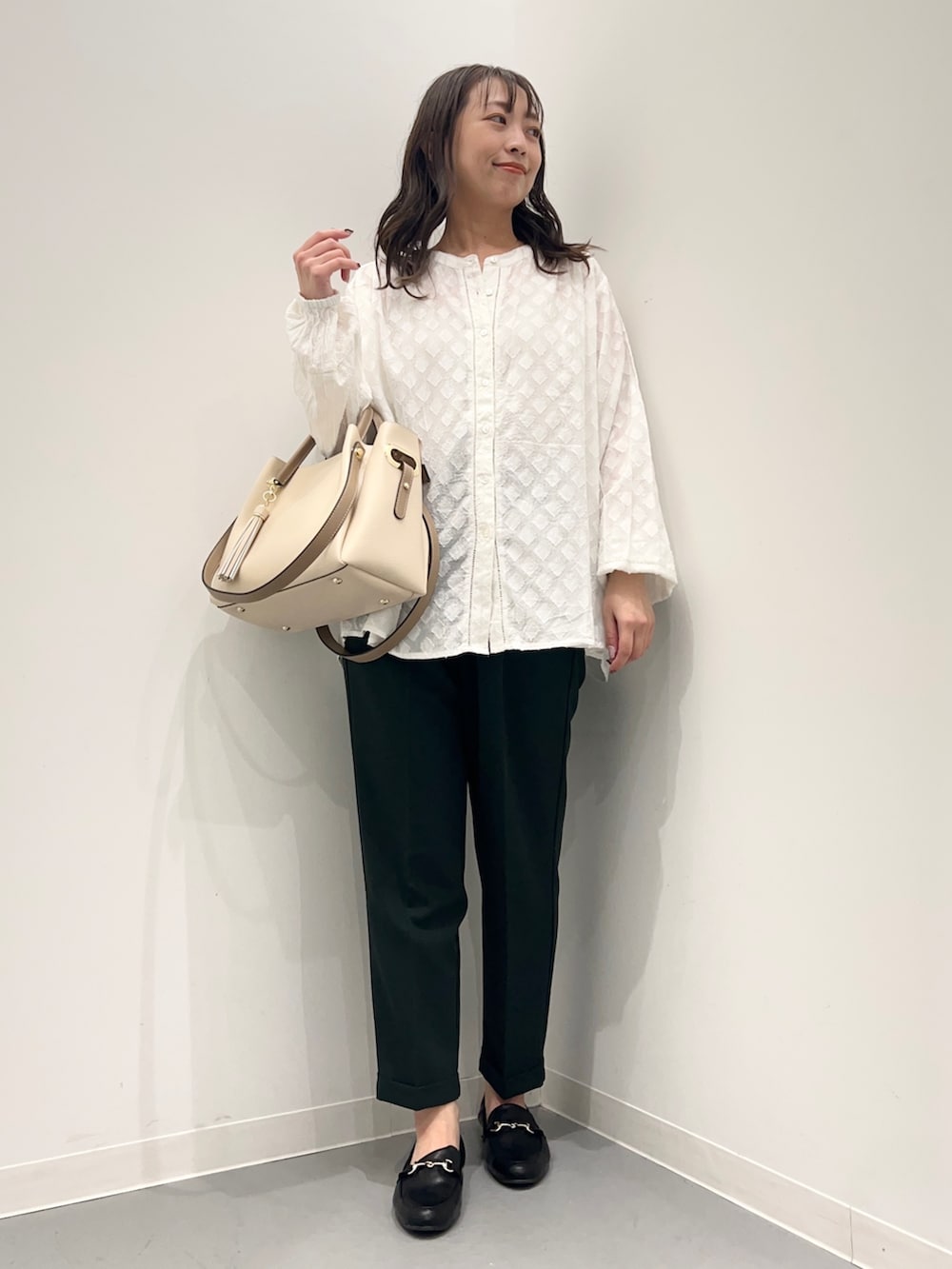 ホワイト系のトップス、グリーン系のパンツを着用したレディースの夏コーディネートの2枚目の写真