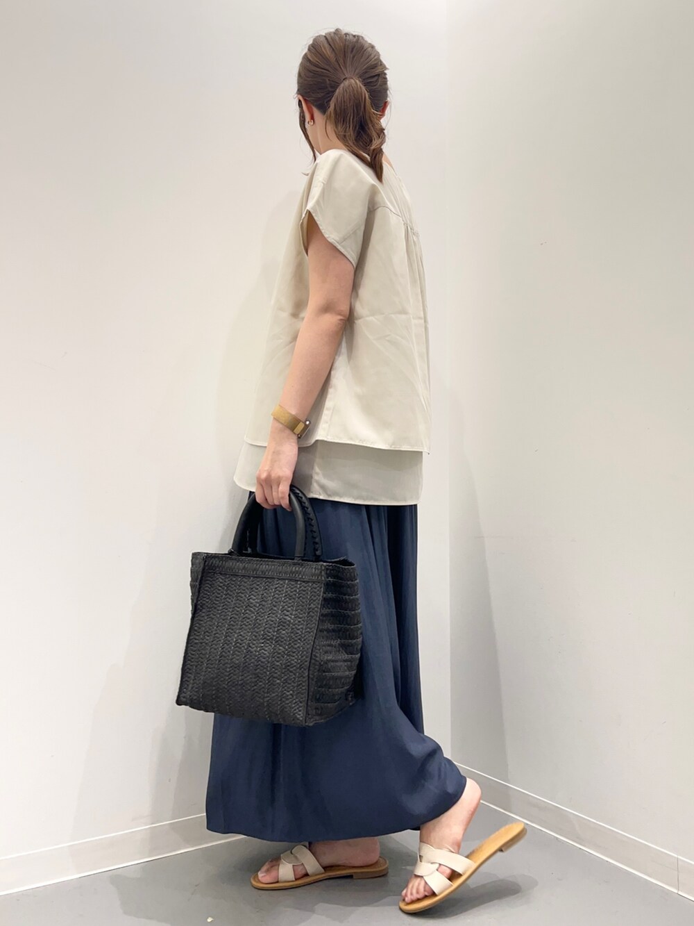 ベージュ系のシャツ/ブラウス、ブルー系のその他パンツ、ブラック系のトートバッグを着用したレディースの夏コーディネートの2枚目の写真