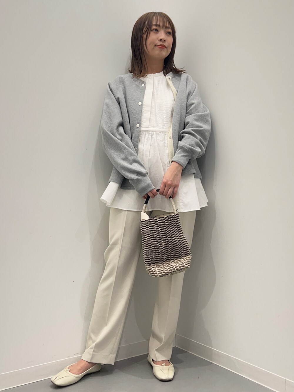 ホワイト系のその他パンツ、ホワイト系のシャツ/ブラウス、グレー系のカーディガン/ボレロを着用したレディースの春コーディネートの2枚目の写真