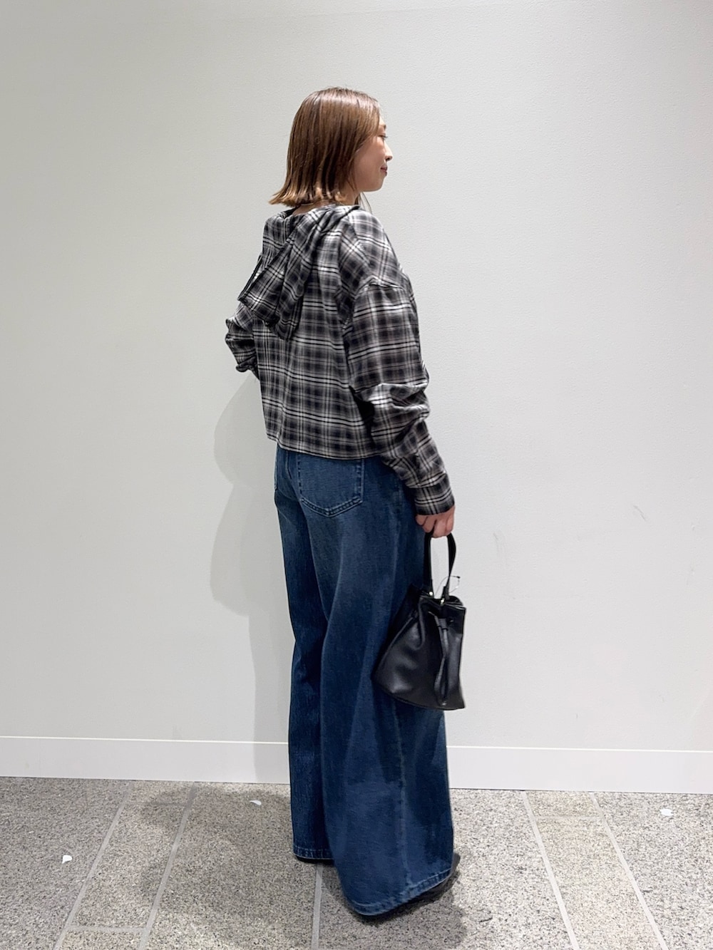 ブラック系のシャツ/ブラウス、ブルー系のデニムパンツ、ブラック系のパンプスを着用したレディースの秋コーディネートの3枚目の写真