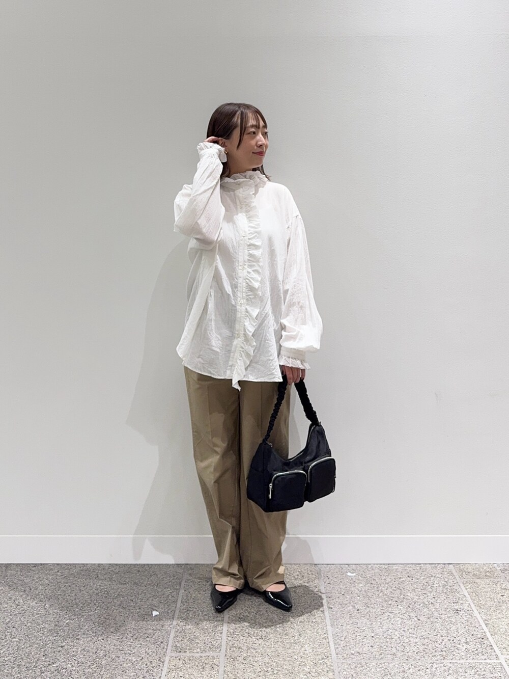 ホワイト系のシャツ/ブラウス、ベージュ系のその他パンツ、ブラック系のショルダーバッグを着用したレディースの秋コーディネートの2枚目の写真