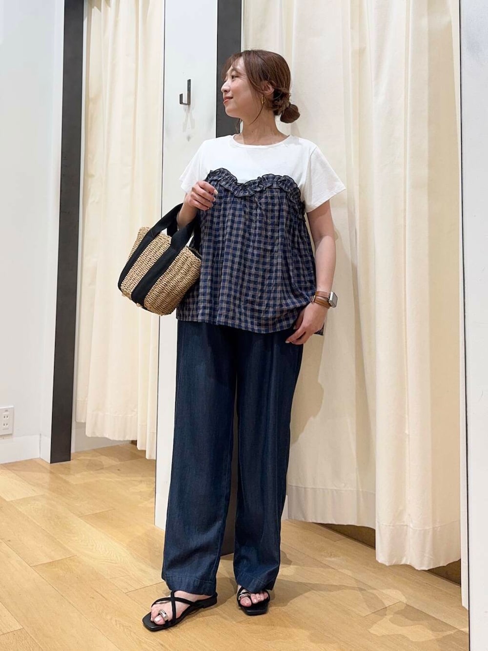 ベージュ系のハンドバッグ、ブルー系のデニムパンツ、ブラック系のサンダルを着用したレディースの夏コーディネートの5枚目の写真