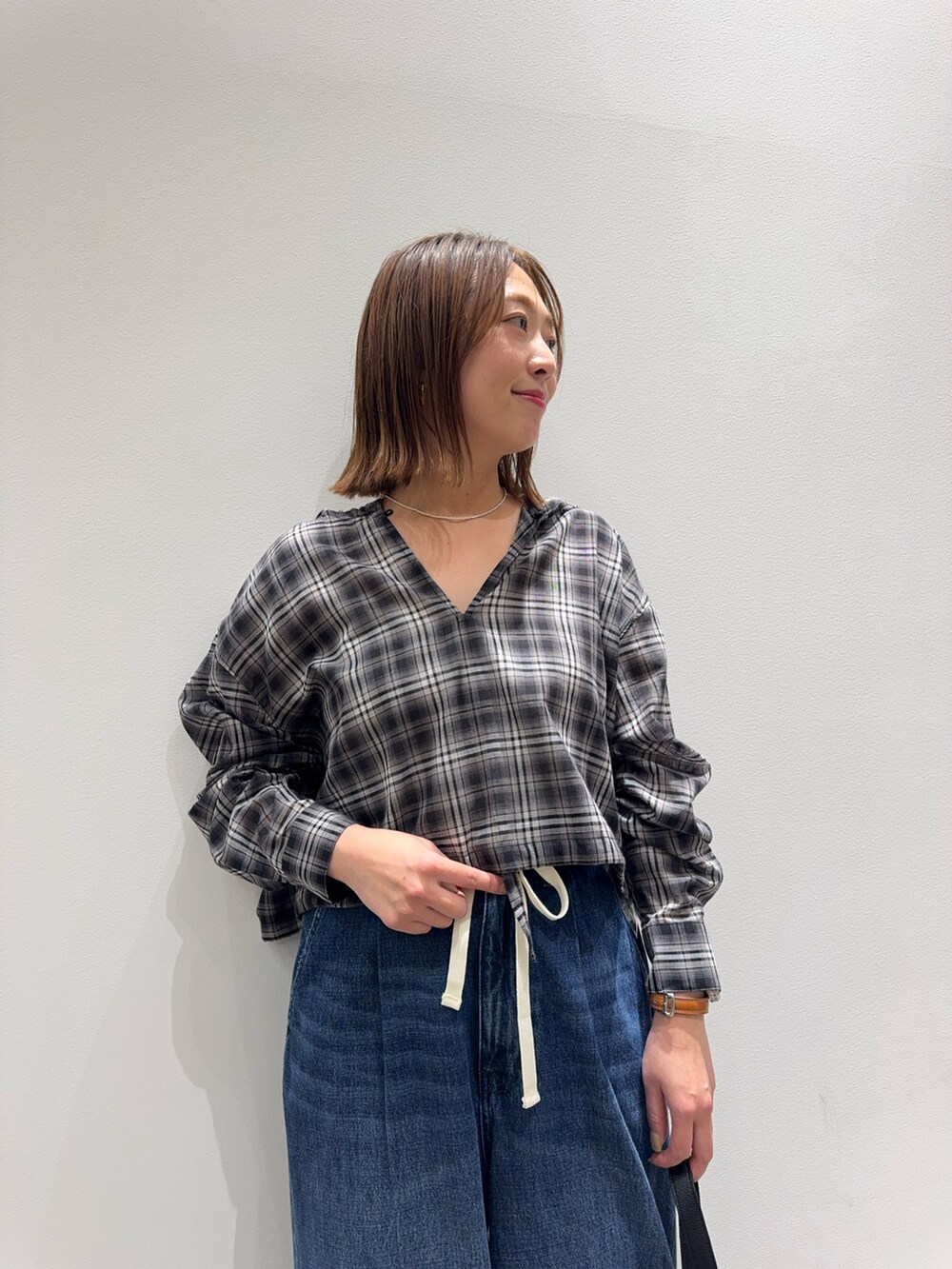 ブラック系のシャツ/ブラウス、ブルー系のデニムパンツ、ブラック系のパンプスを着用したレディースの秋コーディネートの6枚目の写真