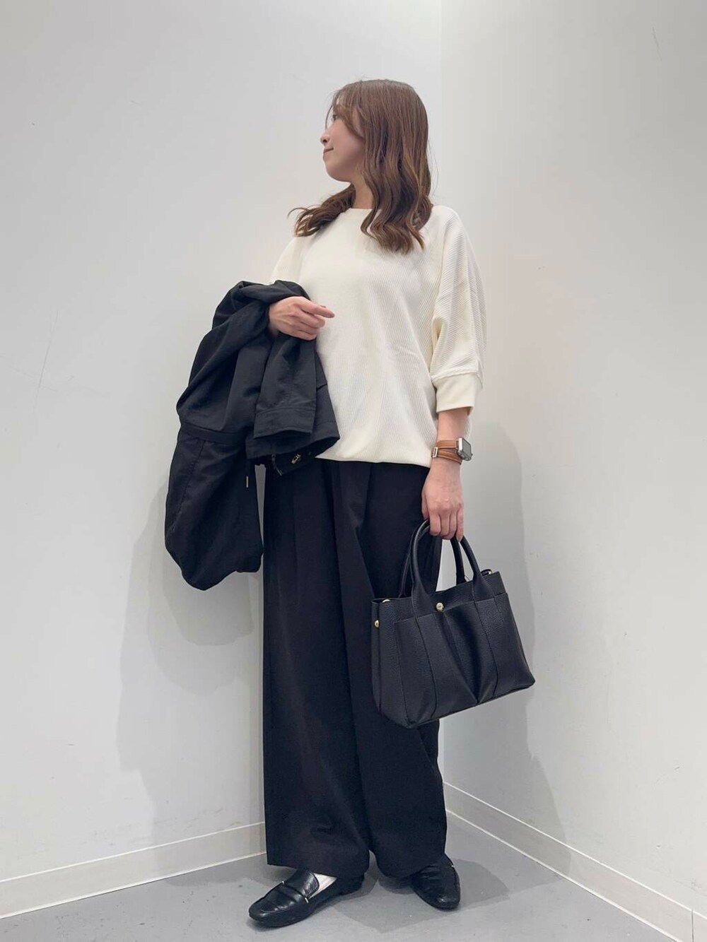 ブラック系のローファー、ベージュ系のTシャツ/カットソー、ブラック系のトートバッグを着用したレディースの春コーディネートの7枚目の写真