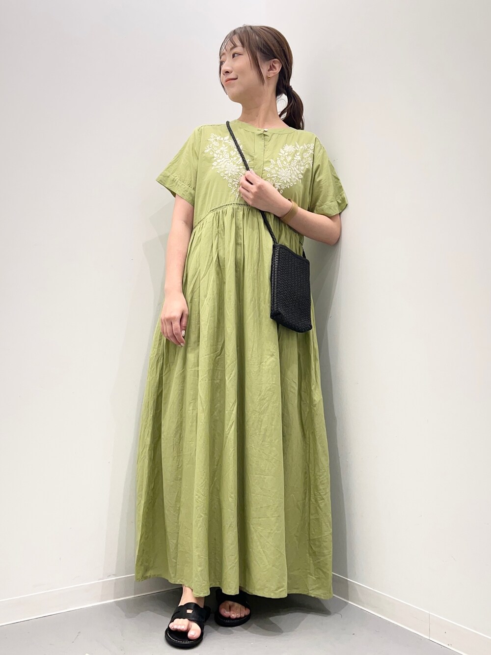 グリーン系のワンピース/ドレス、ブラック系のショルダーバッグ、ブラック系のサンダルを着用したレディースの夏コーディネートの2枚目の写真