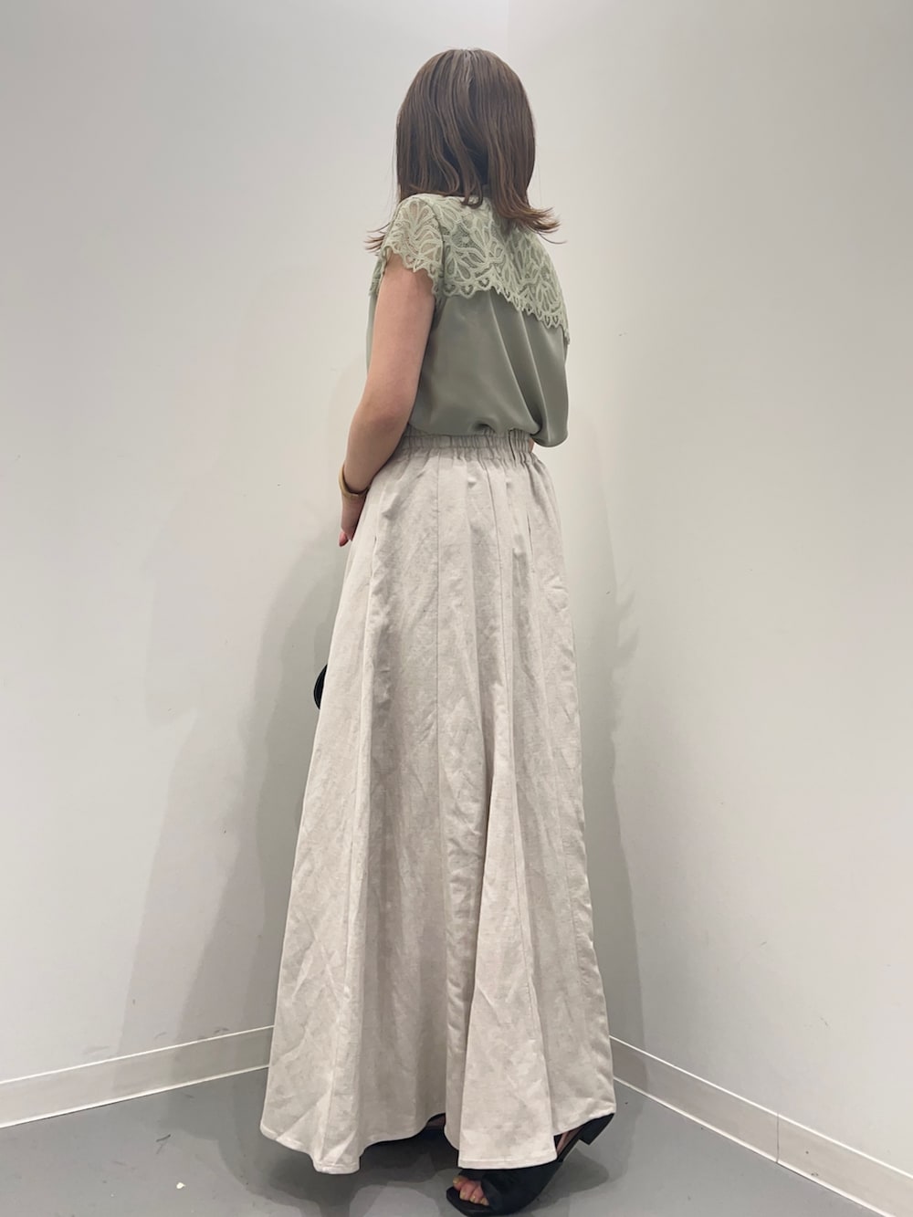 ホワイト系のスカート、グリーン系のシャツ/ブラウス、ブラック系のパンプスを着用したレディースの春コーディネートの4枚目の写真