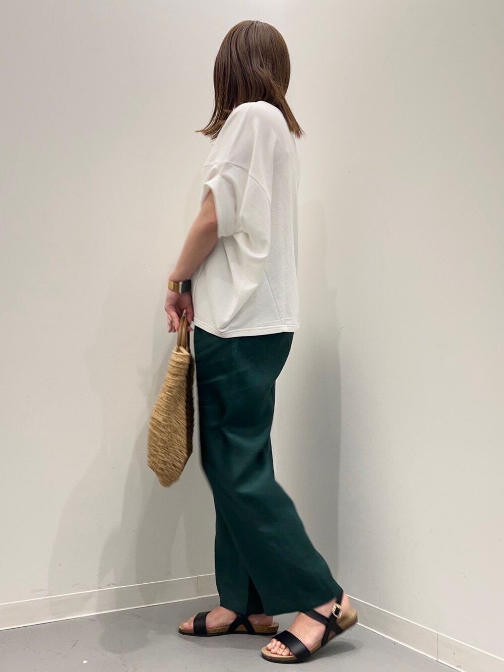 ホワイト系のTシャツ/カットソー、ベージュ系のかごバッグ、グリーン系のその他パンツを着用したレディースの春コーディネートの4枚目の写真