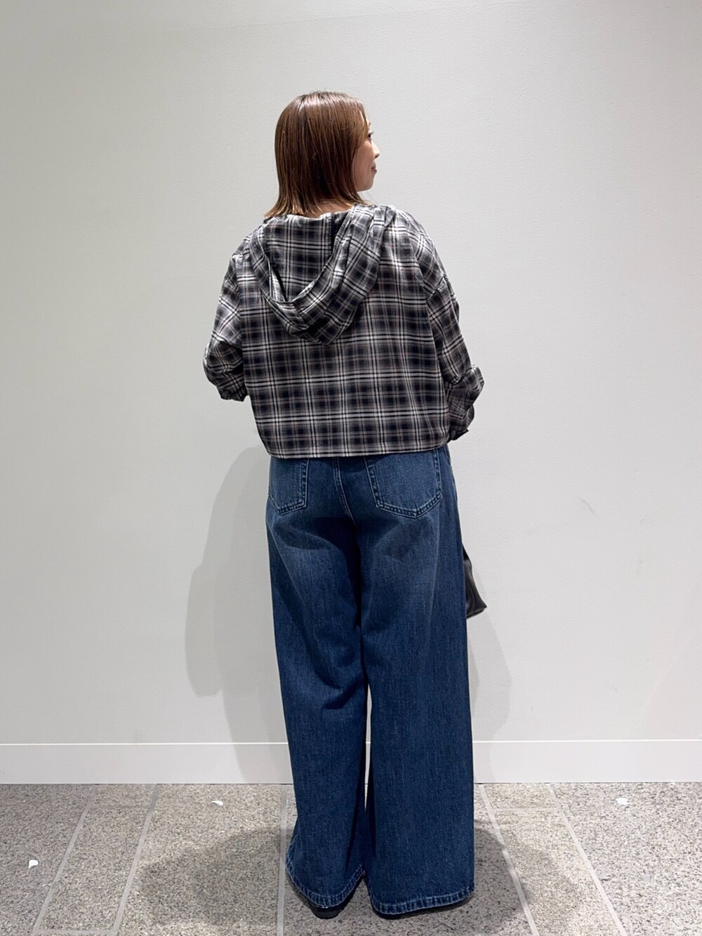 ブラック系のシャツ/ブラウス、ブルー系のデニムパンツ、ブラック系のパンプスを着用したレディースの秋コーディネートの4枚目の写真