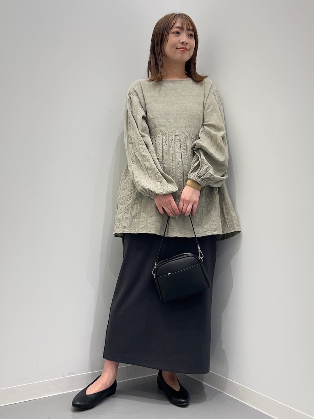 グレー系のシャツ/ブラウス、グレー系のスカート、ブラック系のパンプスを着用したレディースの春コーディネートの3枚目の写真