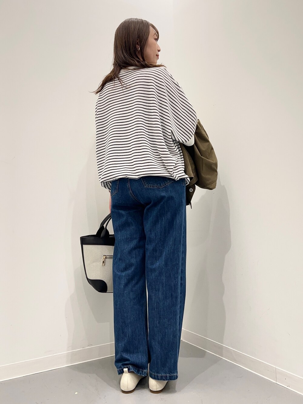 ブルー系のデニムパンツ、グリーン系のその他アウター、ホワイト系のTシャツ/カットソーを着用したレディースの秋コーディネートの10枚目の写真