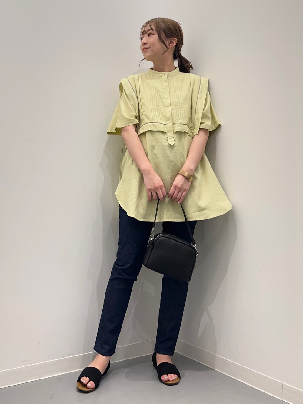 イエロー系のシャツ/ブラウス、ブルー系のデニムパンツ、ブラック系のショルダーバッグを着用したレディースの春コーディネートの3枚目の写真