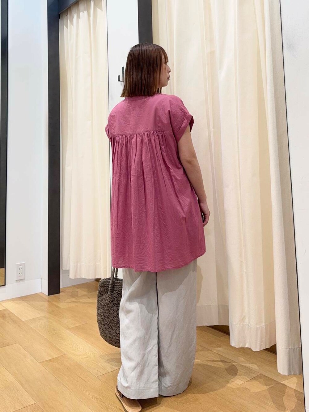 ブラウン系のサンダル、グレー系のトートバッグ、ピンク系のTシャツ/カットソーを着用したレディースの夏コーディネートの4枚目の写真
