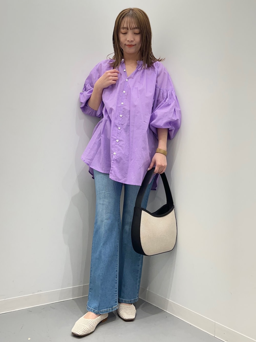 パープル系のシャツ/ブラウス、ブルー系のデニムパンツ、ブラック系のハンドバッグを着用したレディースの春コーディネートの2枚目の写真