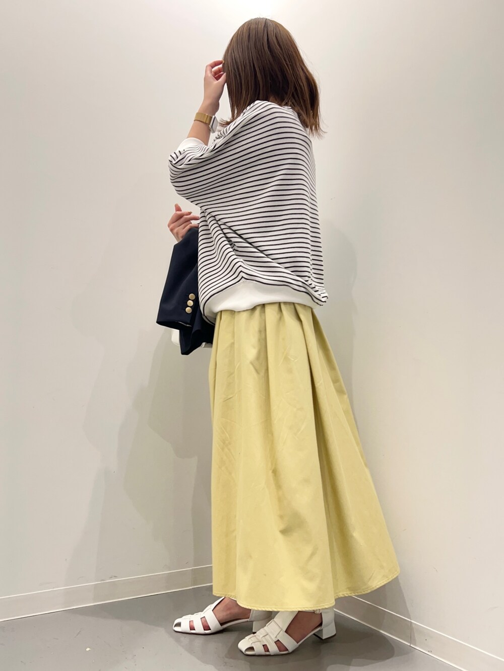 ブルー系のその他アウター、ホワイト系のTシャツ/カットソー、イエロー系のスカートを着用したレディースの春コーディネートの7枚目の写真