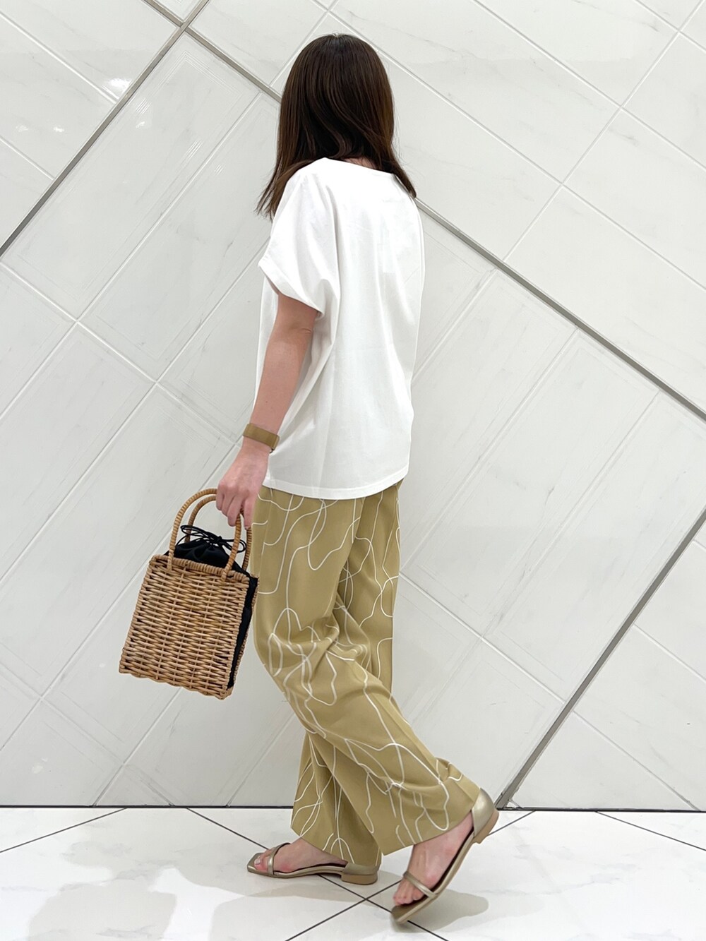 ホワイト系のTシャツ/カットソー、ベージュ系のその他パンツ、ゴールド系のサンダルを着用したレディースの夏コーディネートの4枚目の写真