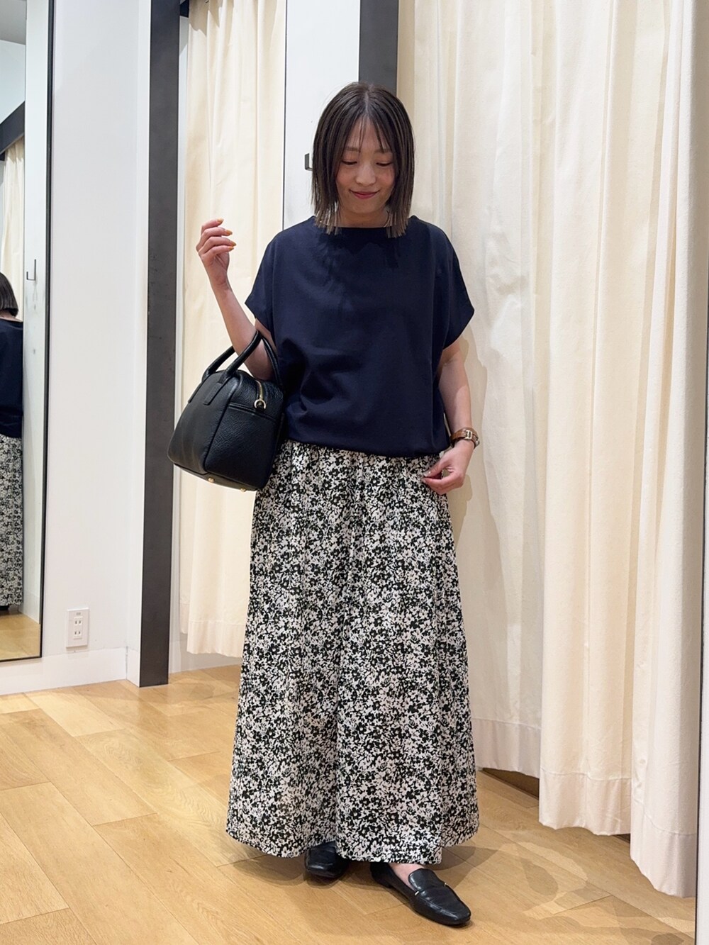 ブルー系のTシャツ/カットソー、ブラック系のスカート、ブラック系のボストンバッグを着用したレディースの夏コーディネートの3枚目の写真