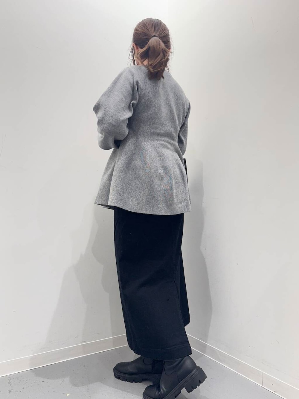 ブラック系のトートバッグ、ブラック系のブーツ、グレー系のニット/セーターを着用したレディースの冬コーディネートの2枚目の写真