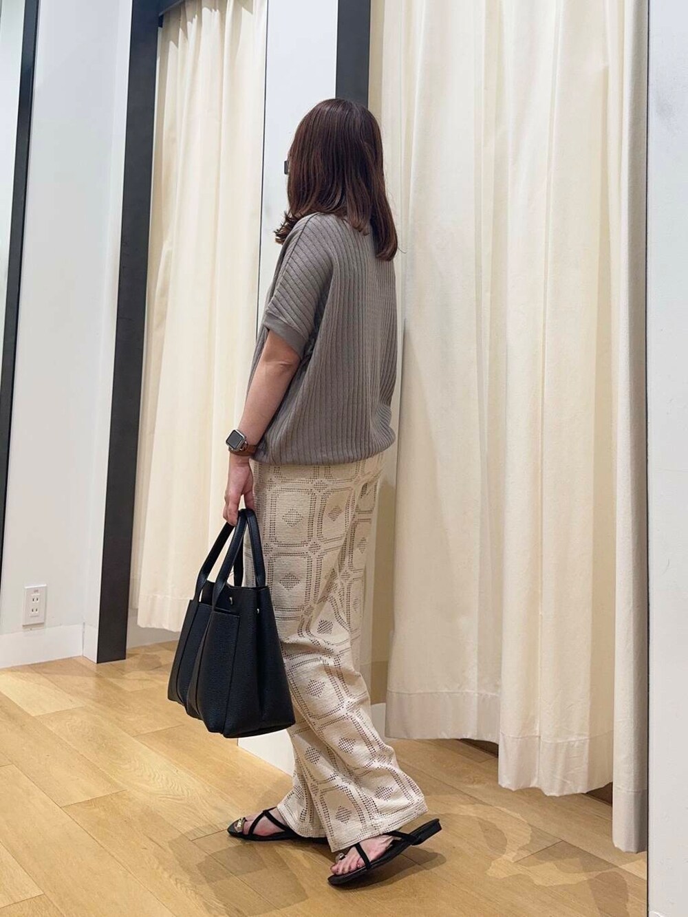ブラック系のトートバッグ、ベージュ系のその他パンツ、ブラック系のサンダルを着用したレディースの夏コーディネートの2枚目の写真