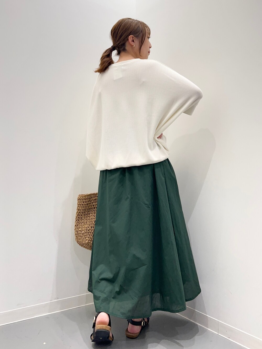 ベージュ系のTシャツ/カットソー、グリーン系のスカート、ブラック系のサンダルを着用したレディースの春コーディネートの5枚目の写真