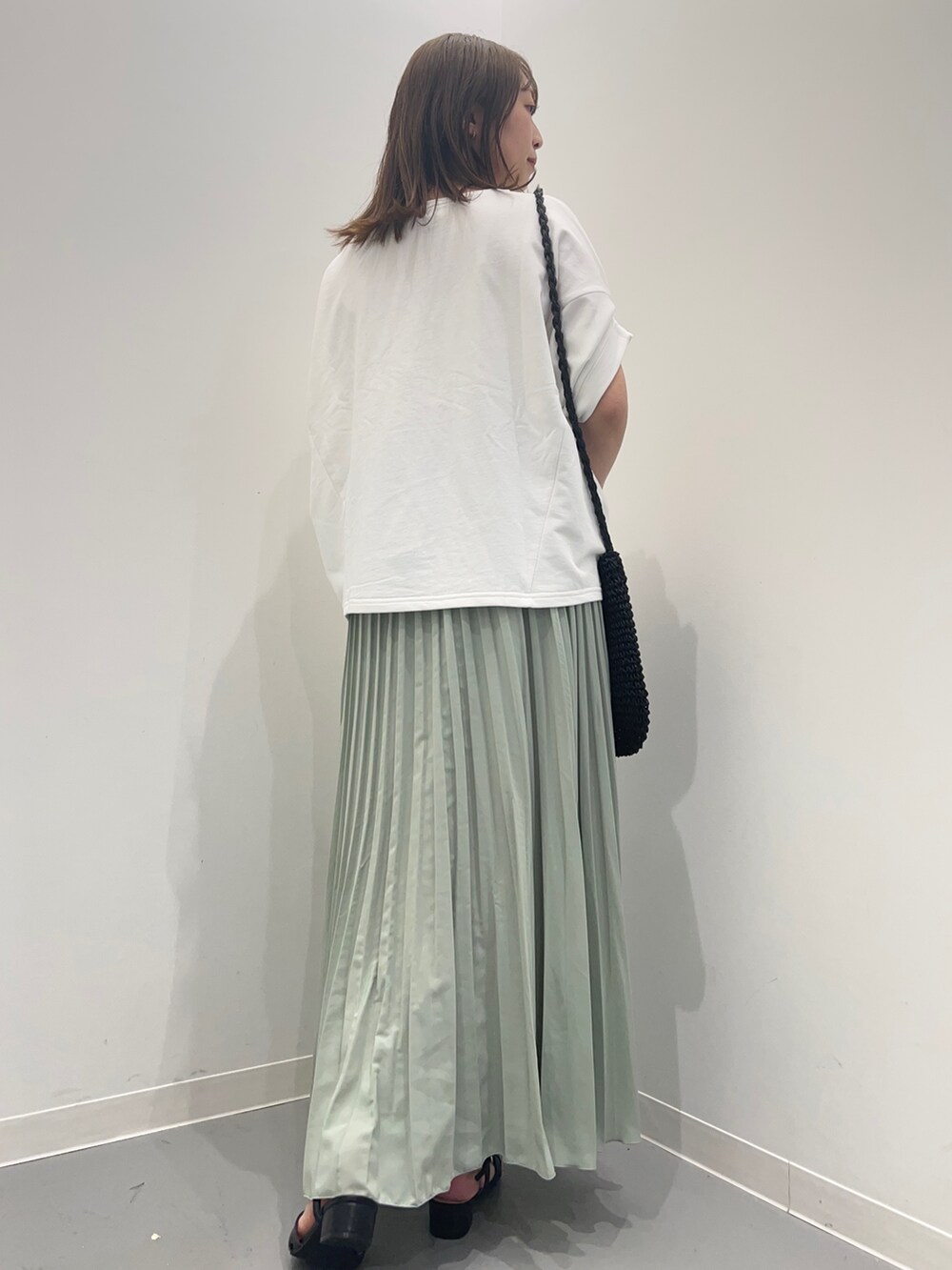 ホワイト系のTシャツ/カットソー、グリーン系のスカートを着用したレディースの春コーディネートの5枚目の写真