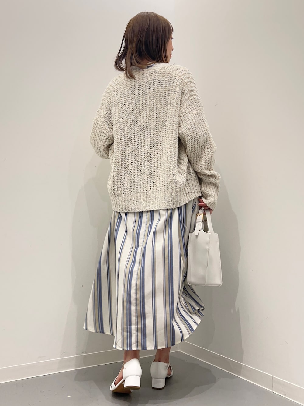 ホワイト系のカーディガン/ボレロ、ホワイト系のサンダル、ブルー系のワンピースを着用したレディースの春コーディネートの7枚目の写真