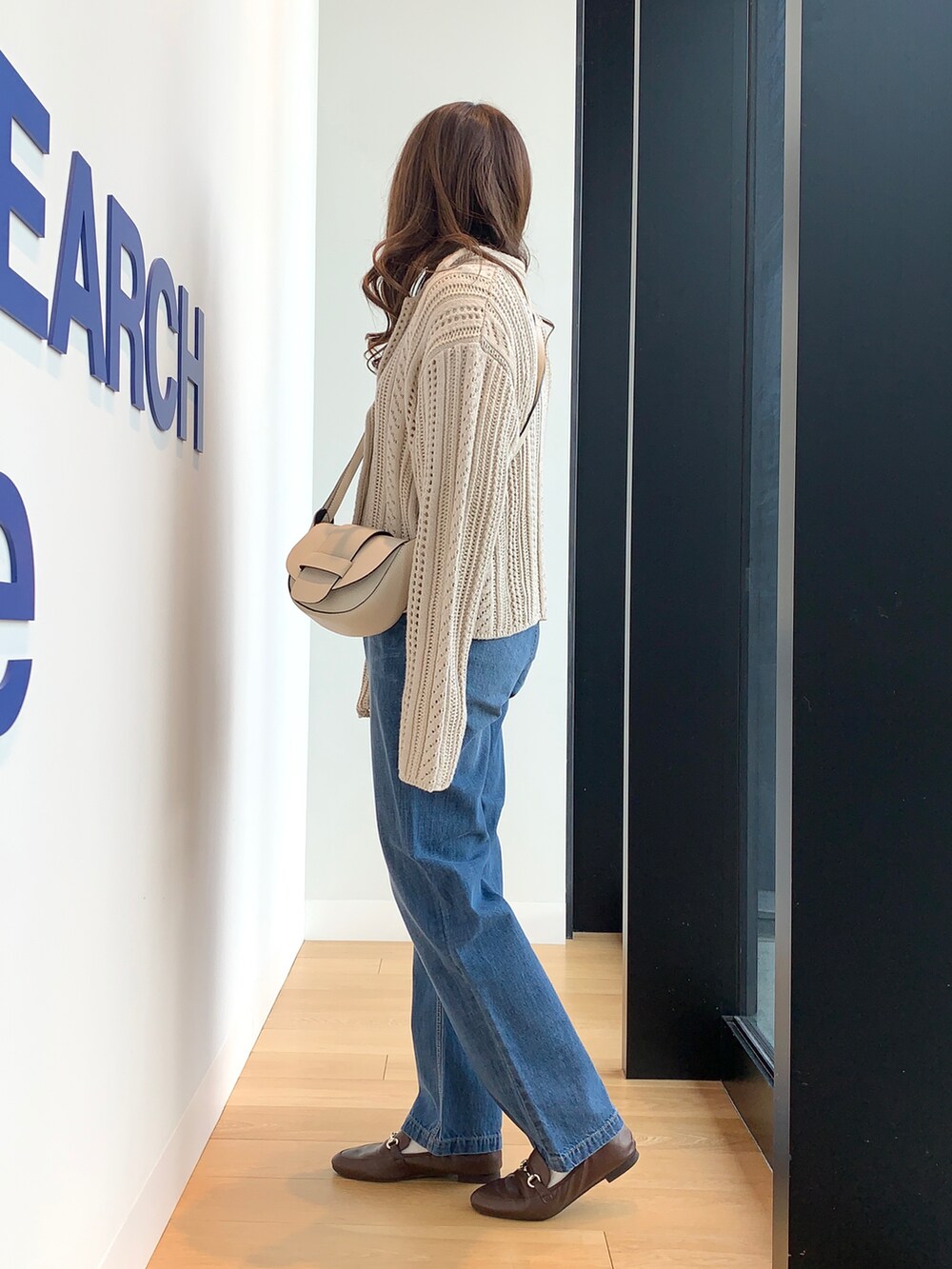 ブルー系のデニムパンツ、ベージュ系のニット/セーターを着用したレディースの冬コーディネートの3枚目の写真