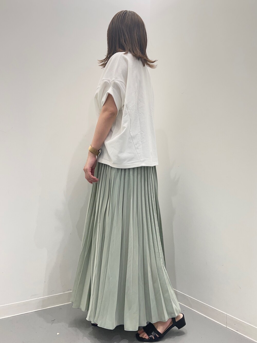 ホワイト系のTシャツ/カットソー、グリーン系のスカートを着用したレディースの春コーディネートの4枚目の写真