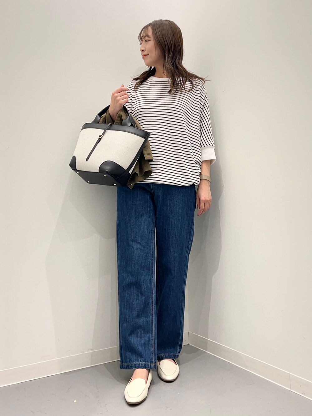 ブルー系のデニムパンツ、グリーン系のその他アウター、ホワイト系のTシャツ/カットソーを着用したレディースの秋コーディネートの6枚目の写真