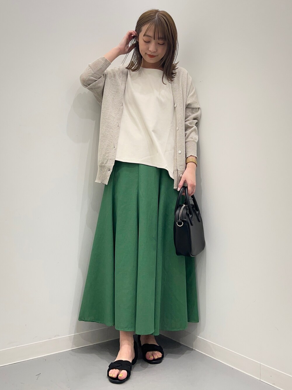 グレー系のTシャツ/カットソー、ブラック系のサンダル、グリーン系のスカートを着用したレディースの春コーディネートの5枚目の写真