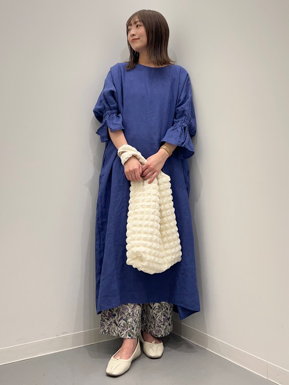 ブルー系のワンピース、パープル系のその他パンツ、ホワイト系のトートバッグを着用したレディースの春コーディネートの2枚目の写真