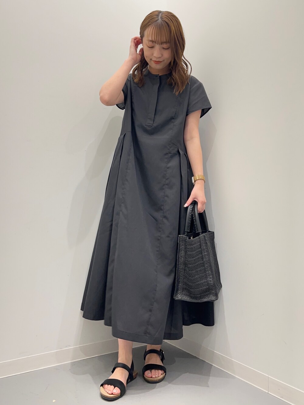 グレー系のワンピース、ブラック系のトートバッグ、ブラック系のサンダルを着用したレディースの春コーディネートの6枚目の写真