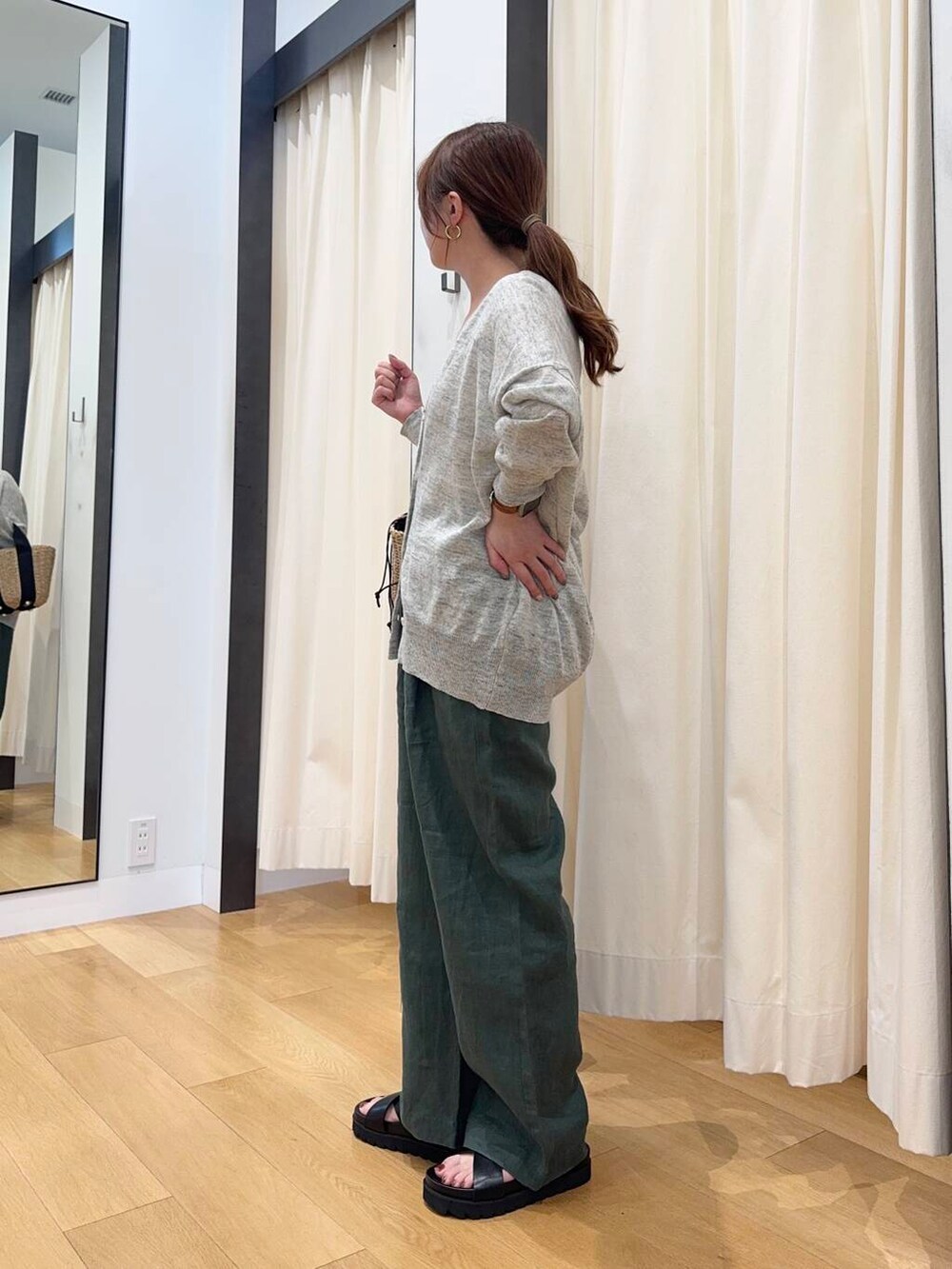 グレー系のカーディガン/ボレロ、ベージュ系のハンドバッグ、グリーン系のその他パンツを着用したレディースの春コーディネートの3枚目の写真