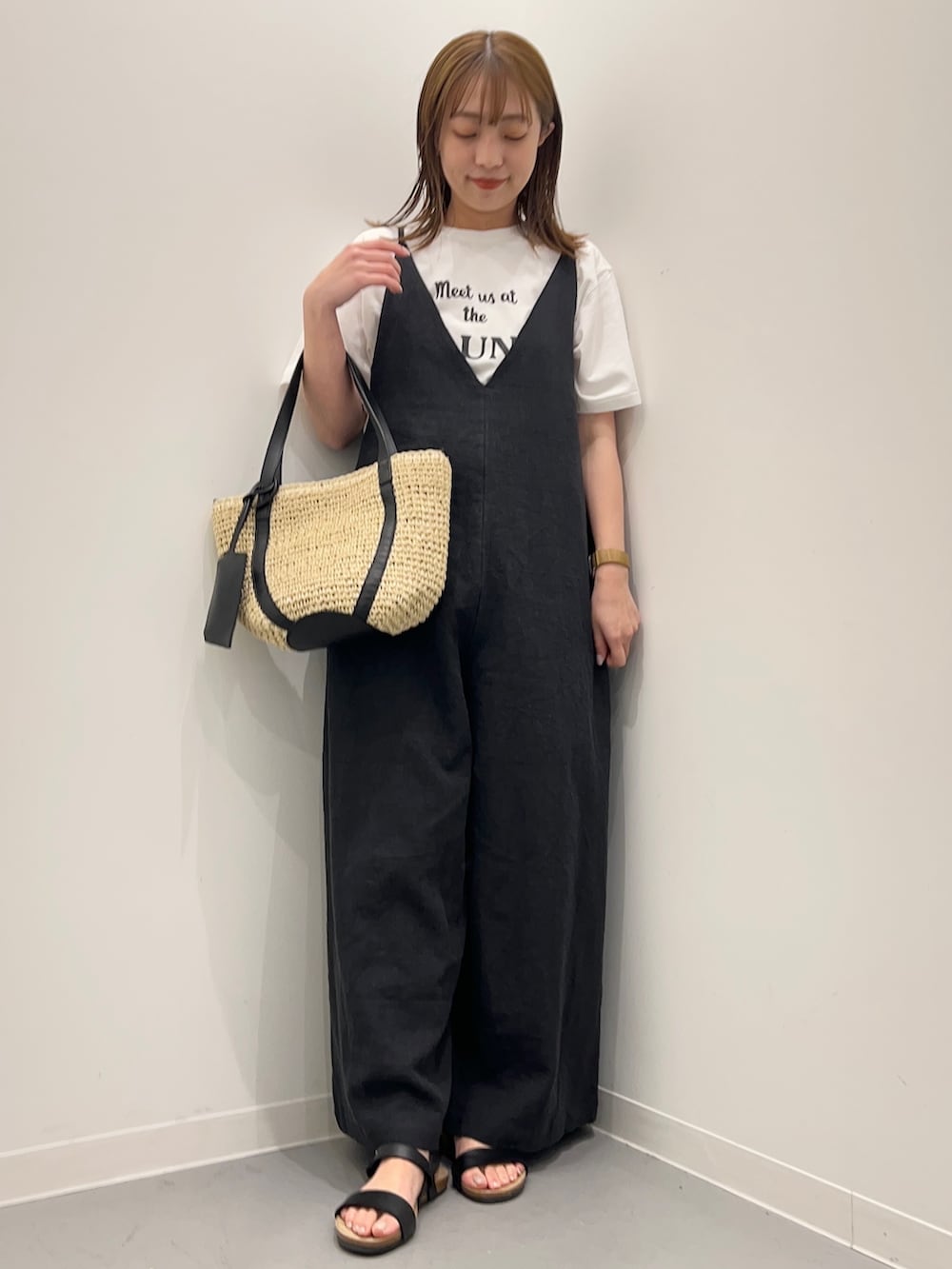 ホワイト系のTシャツ/カットソー、ブラック系のサロペット/オーバーオール、ブラック系のサンダルを着用したレディースの春コーディネートの4枚目の写真