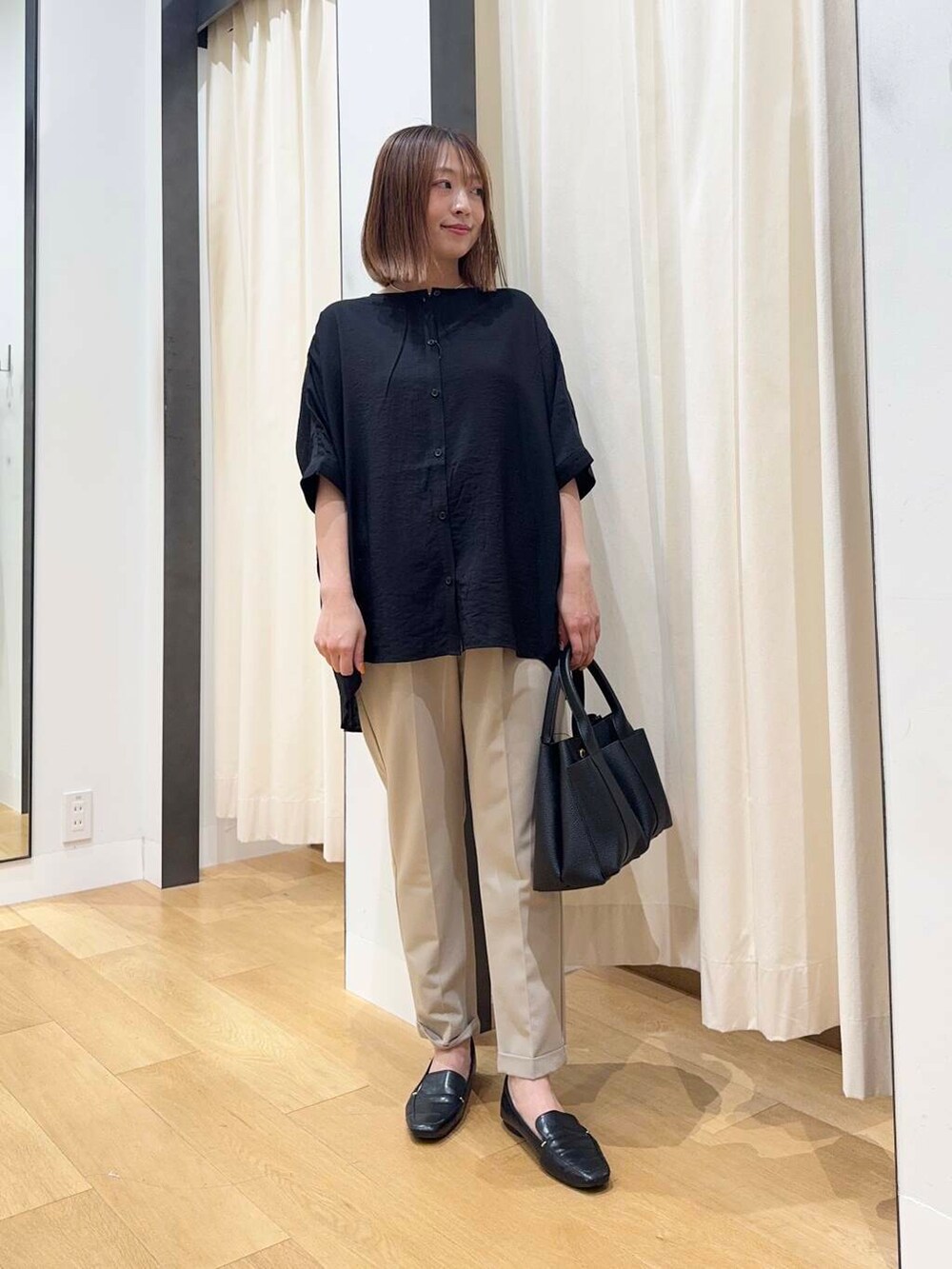 ブラック系のトートバッグ、ベージュ系のその他パンツ、ブラック系のシャツ/ブラウスを着用したレディースの夏コーディネートの3枚目の写真