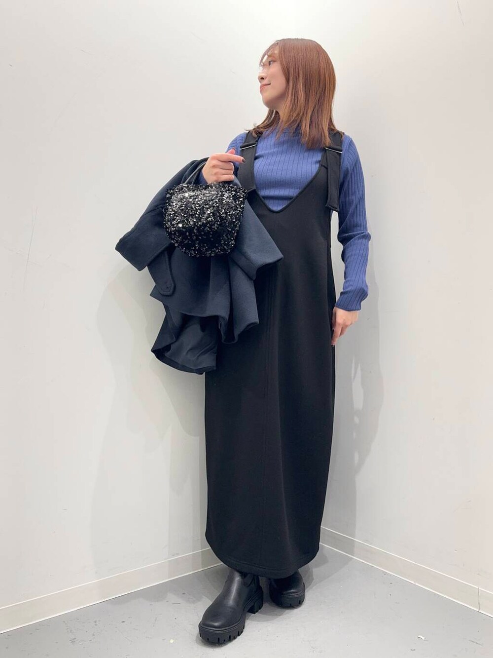 ブラック系のショルダーバッグ、ブラック系のブーツ、ブルー系のステンカラーコートを着用したレディースの冬コーディネートの5枚目の写真