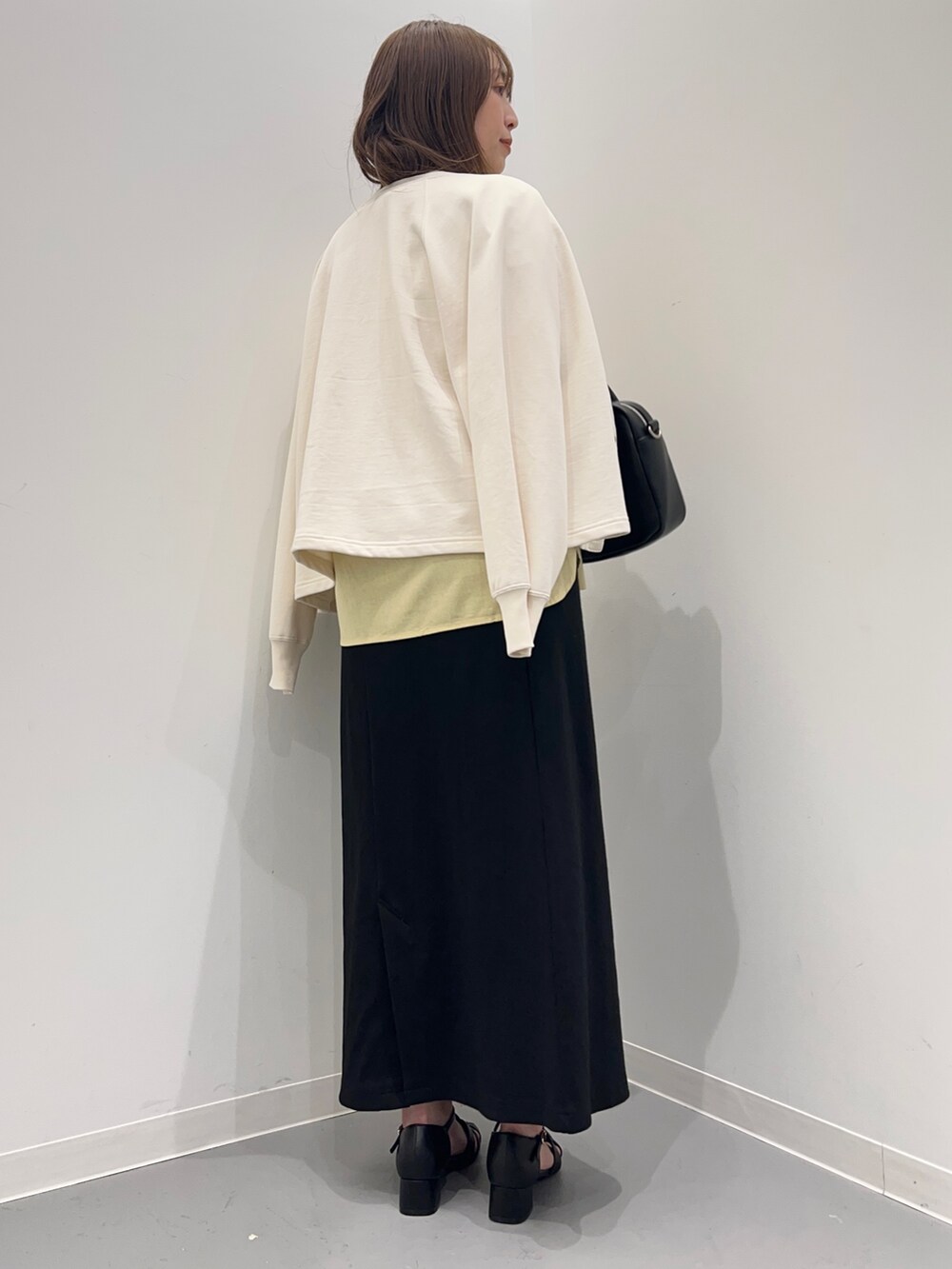 イエロー系のシャツ/ブラウス、ブラック系のスカート、ホワイト系のカーディガン/ボレロを着用したレディースの春コーディネートの5枚目の写真