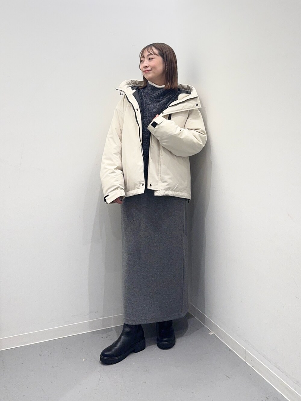 ホワイト系のダウンジャケット/コート、グレー系のニット/セーター、グレー系のスカートを着用したレディースの冬コーディネートの5枚目の写真