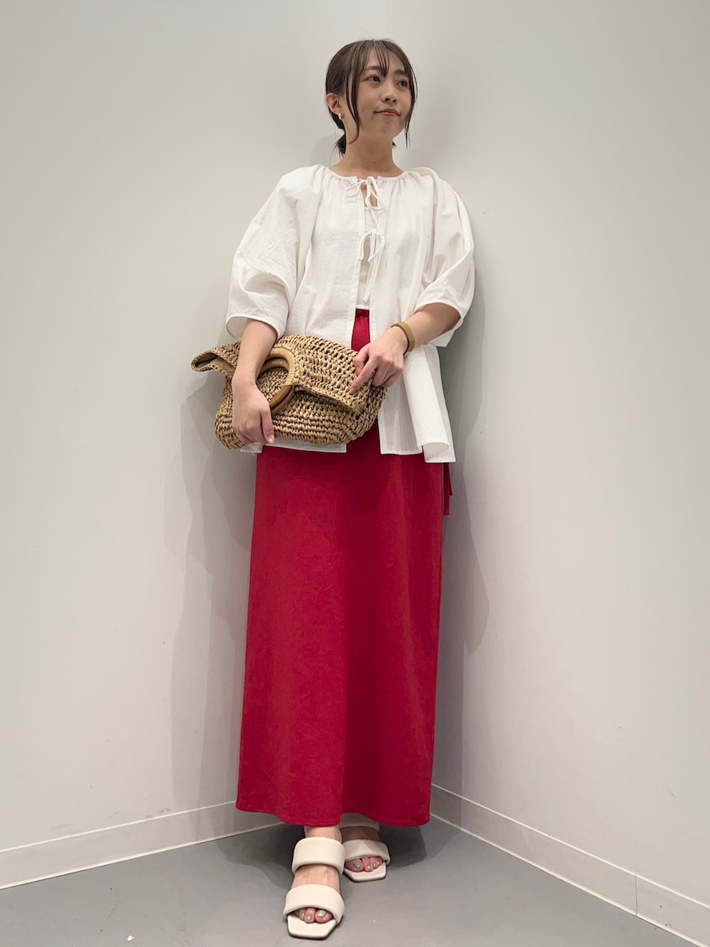 ホワイト系のシャツ/ブラウス、レッド系のスカート、ホワイト系のサンダルを着用したレディースの夏コーディネートの2枚目の写真