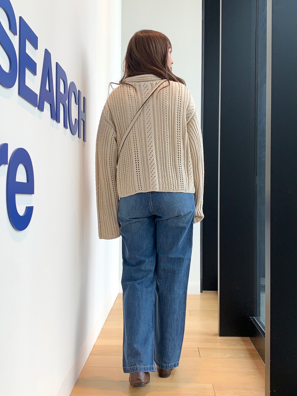 ブルー系のデニムパンツ、ベージュ系のニット/セーターを着用したレディースの冬コーディネートの4枚目の写真