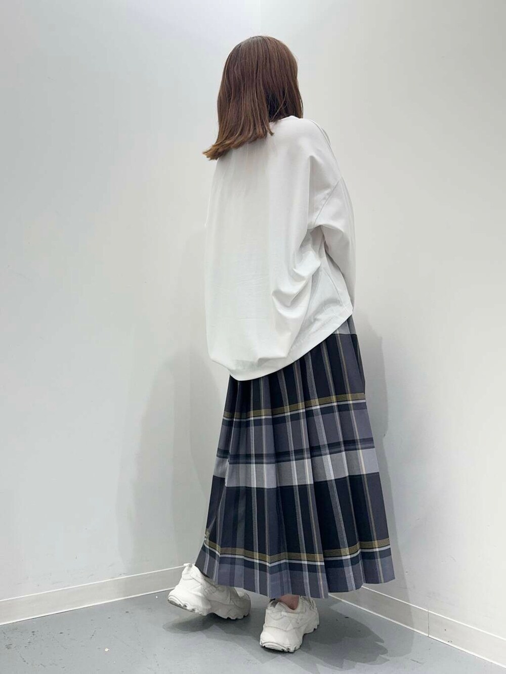 ブラック系のショルダーバッグ、ホワイト系のスニーカー、ホワイト系のTシャツ/カットソーを着用したレディースの秋コーディネートの3枚目の写真