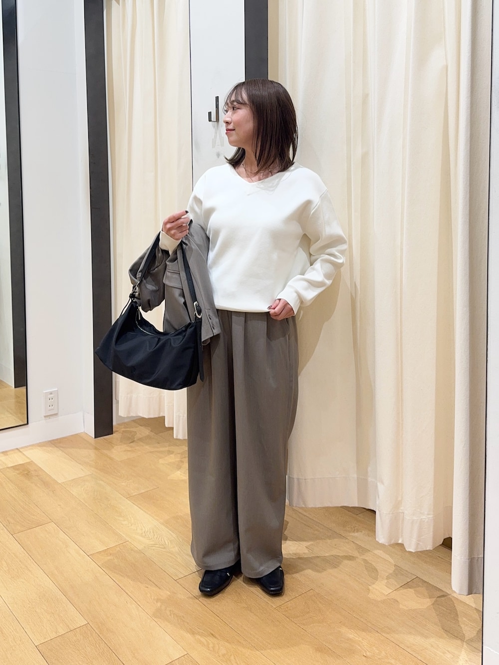 グレー系のその他アウター、ホワイト系のニット/セーター、グレー系のその他パンツを着用したレディースの冬コーディネートの4枚目の写真