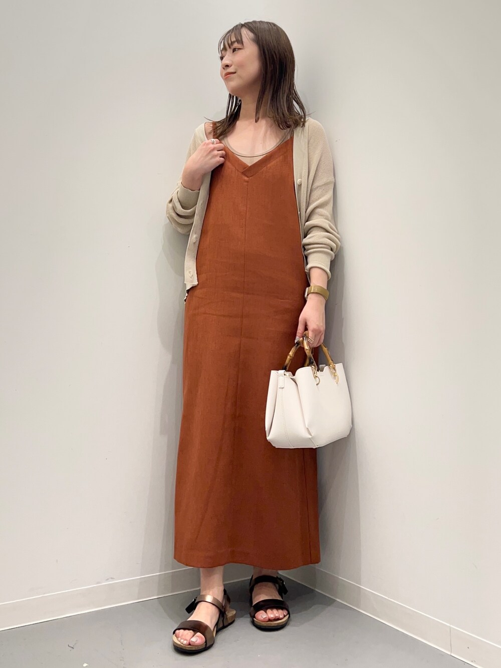 レッド系のワンピース、ベージュ系のカーディガン/ボレロ、ブラウン系のタンクトップを着用したレディースの夏コーディネートの2枚目の写真