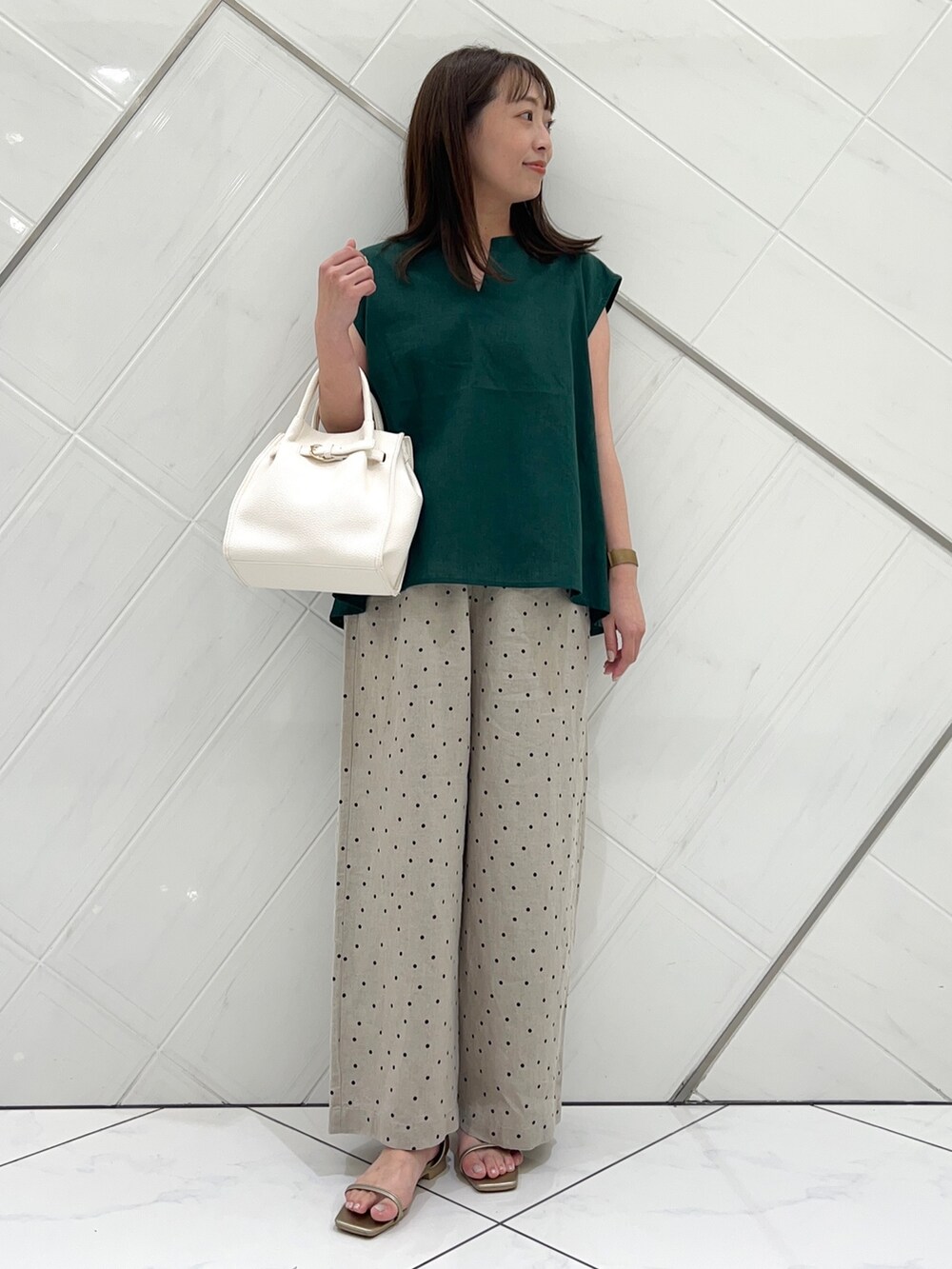 グリーン系のシャツ/ブラウス、ベージュ系のその他パンツ、ゴールド系のサンダルを着用したレディースの夏コーディネートの2枚目の写真