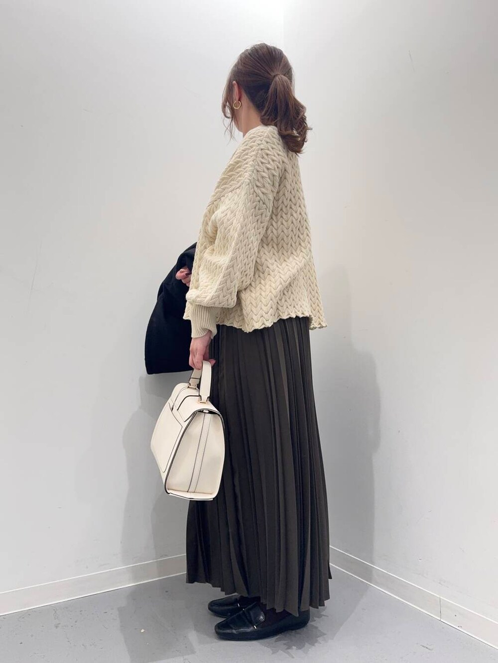 ブラック系のローファー、ブラック系のその他アウター、ホワイト系のハンドバッグを着用したレディースの冬コーディネートの5枚目の写真